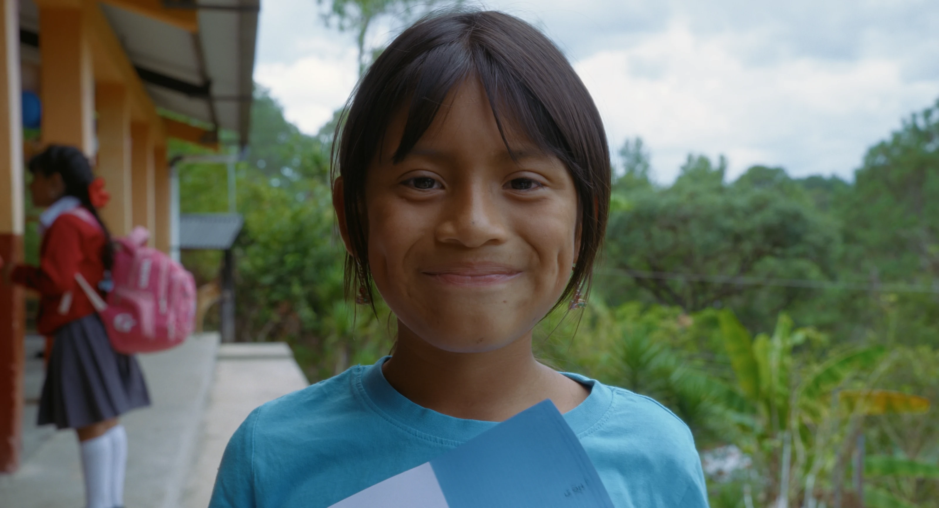 A smiling student outside a school in Guatemala.