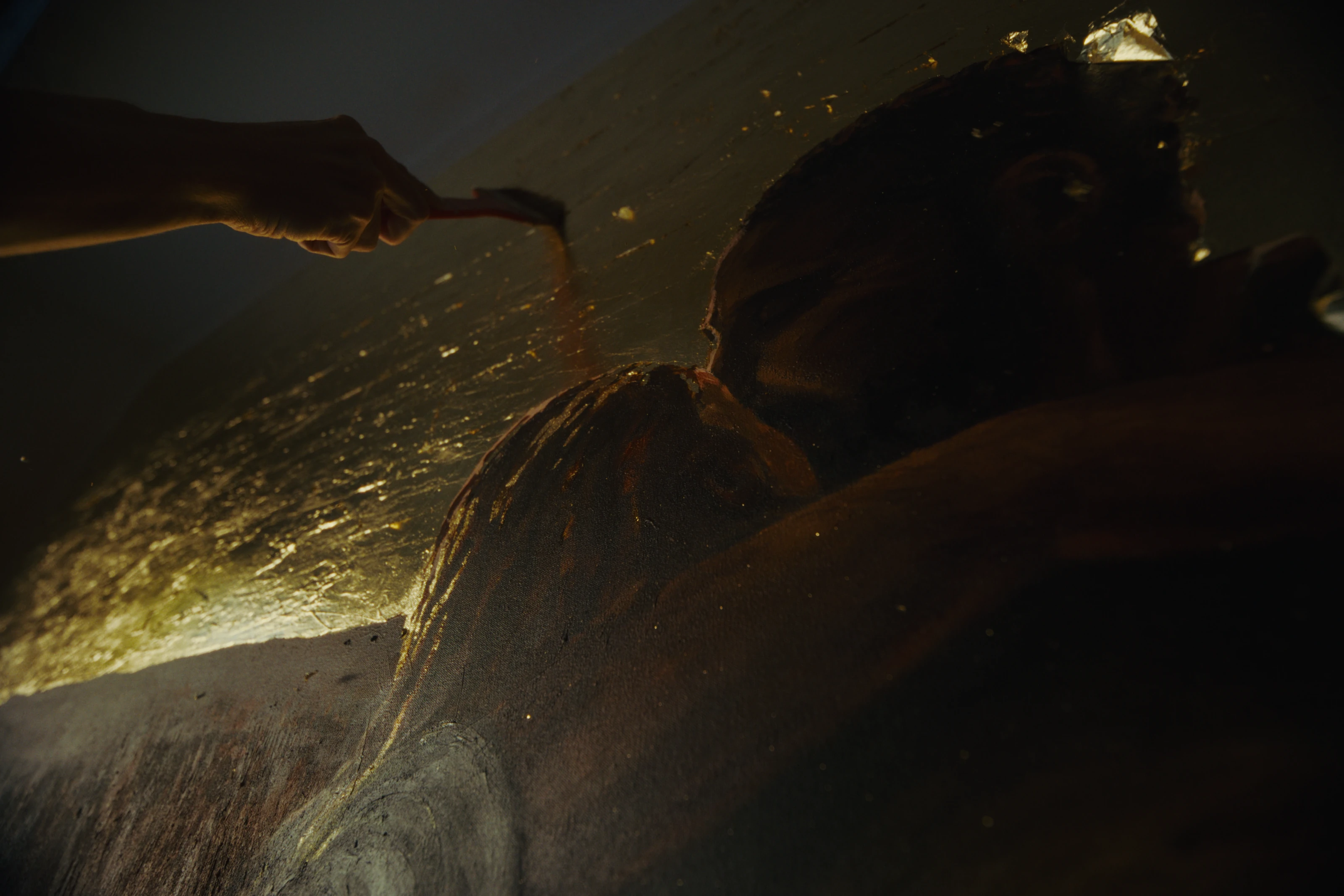 A dark, gold-lit detail from The Prodigal Son: A Mural.
